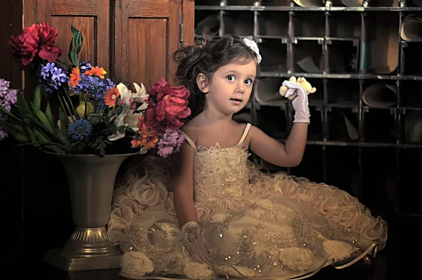 Una chica hermosa, un niño con un bonito vestido y un jarrón de flores —  Fotos de Stock