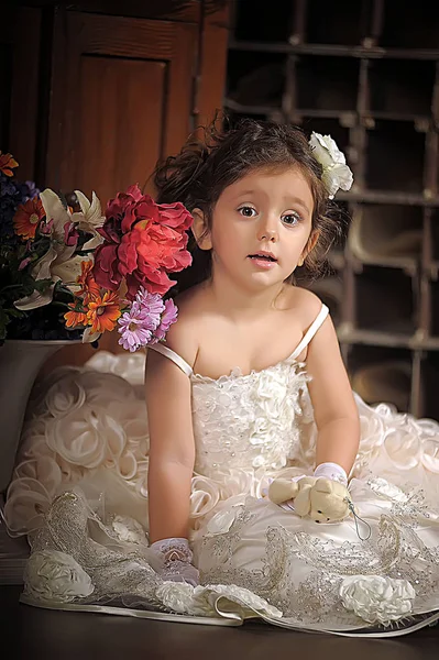 Une belle fille, un enfant dans une belle robe et un vase de fleurs — Photo