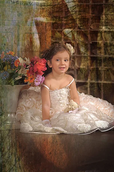 Una chica hermosa, un niño con un bonito vestido y un jarrón de flores — Foto de Stock