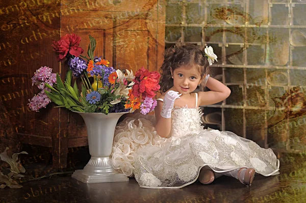 Una chica hermosa, un niño con un bonito vestido y un jarrón de flores —  Fotos de Stock