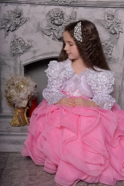 Söt flicka prinsessa med lockigt hår i en vit med rosa klänning — Stockfoto