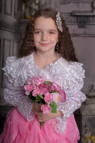 Bonito menina princesa com cabelos cacheados e flores em seus braços, brun — Fotografia de Stock