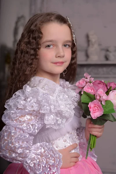 Χαριτωμένο κορίτσι πριγκίπισσα με σγουρά μαλλιά και λουλούδια στην αγκαλιά της, Brun — Φωτογραφία Αρχείου