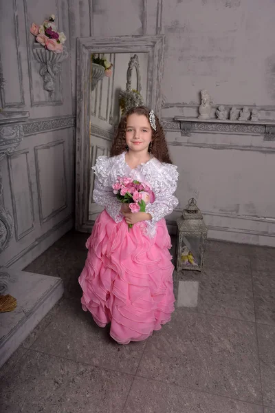 Prinses meisje in wit met een roze jurk met bloemen — Stockfoto