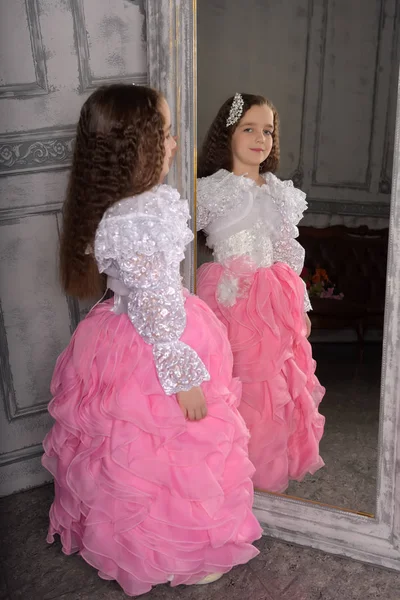 Princesa menina em branco com um vestido rosa perto do espelho — Fotografia de Stock