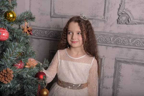 Niña en vestido de fiesta de marfil en Navidad con una corona —  Fotos de Stock