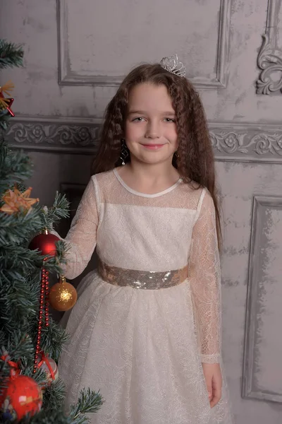 Menina em marfim vestido festivo no Natal com uma coroa — Fotografia de Stock