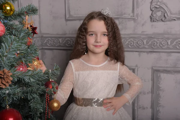 Niña en vestido de fiesta de marfil en Navidad con una corona —  Fotos de Stock