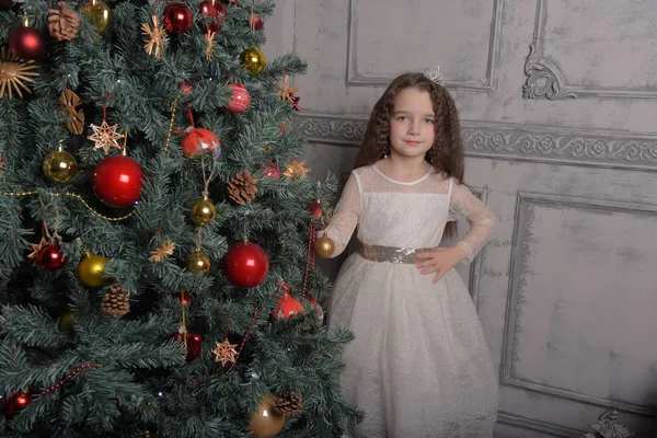 Meisje in ivoor feestelijke jurk in kerst met een kroon — Stockfoto