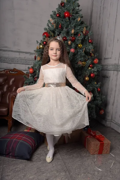 Menina em marfim vestido festivo no Natal com uma coroa — Fotografia de Stock