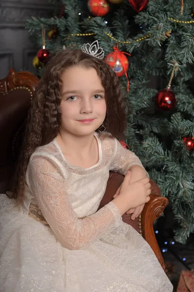 Niña en vestido de fiesta de marfil en Navidad con una corona — Foto de Stock