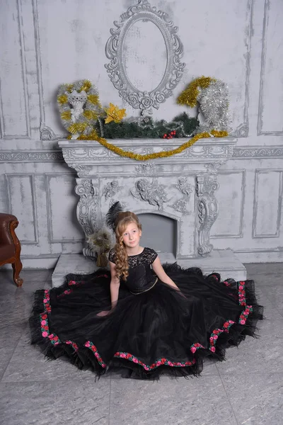Dziewczyna w eleganckim czarny sukienka siedzi w szary — Zdjęcie stockowe