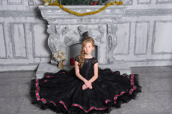 Chica en elegante vestido negro está sentado en el gris — Foto de Stock