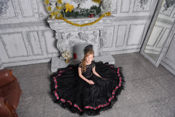 Chica en elegante vestido negro está sentado en el gris — Foto de Stock