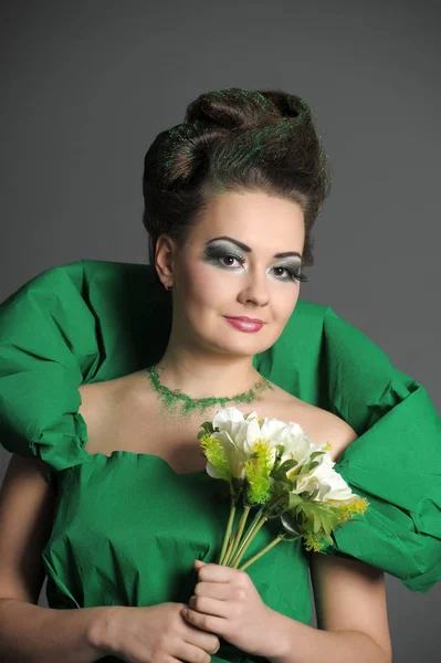 Портрет девушки в зеленом с стильной укладкой волос и креативами — стоковое фото