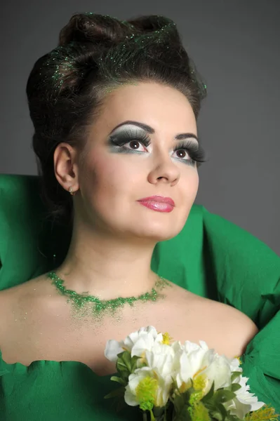 Ritratto di una ragazza in verde con acconciatura elegante e crea — Foto Stock