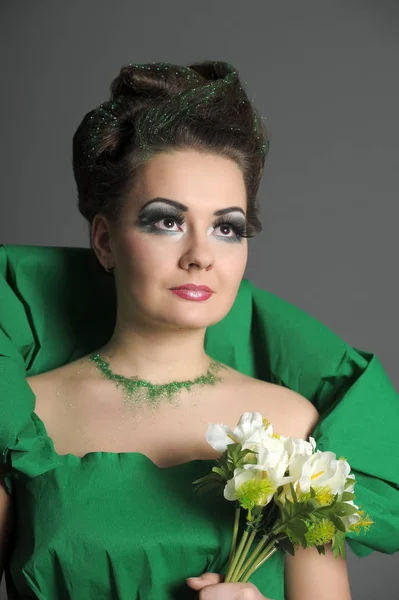 Ritratto di una ragazza in verde con acconciatura elegante e crea — Foto Stock