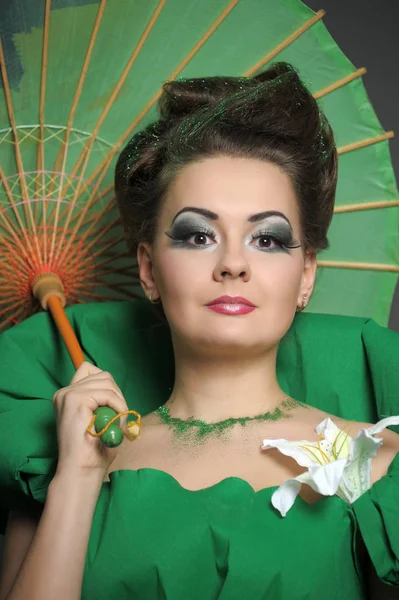 Menina em verde com estilo de cabelo elegante e criatividade make-up sagacidade — Fotografia de Stock