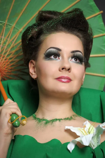 Menina em verde com estilo de cabelo elegante e criatividade make-up sagacidade — Fotografia de Stock