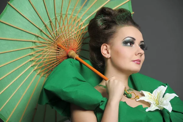 Menina em verde com estilo de cabelo elegante e criatividade make-up sagacidade — Fotografia de Stock