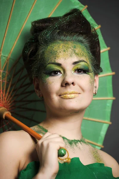 Menina em verde com estilo de cabelo elegante e criatividade make-up sagacidade — Fotografia de Stock