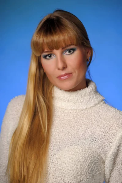 Beautiful long-haired blonde in a studio on a blue background — 스톡 사진