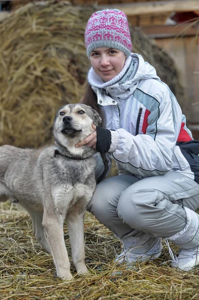 Chica en ropa de invierno con un perro — Foto de Stock