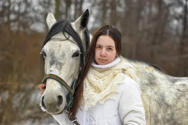 Dziewczyna w białym płaszczu w zimie z koniem — Zdjęcie stockowe