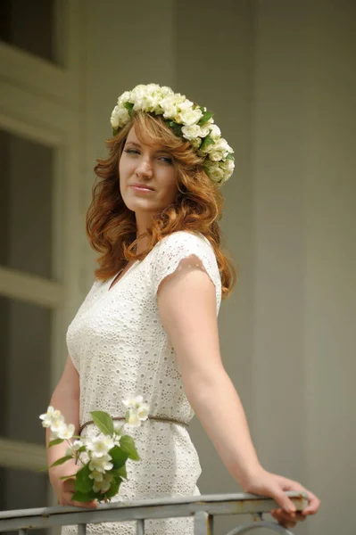 Beautiful young brunette in a wreath of white flowers — 스톡 사진