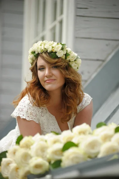 Porträt einer schönen Frau mit einem Strauß weißer Rosen. — Stockfoto