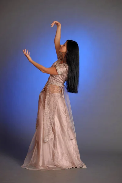 ブルネット女の子で東洋のドレス上の青背景でザスタッド — ストック写真