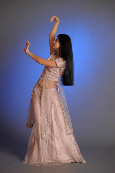 Brunette girl in oriental dress on a blue background in the stud — 스톡 사진