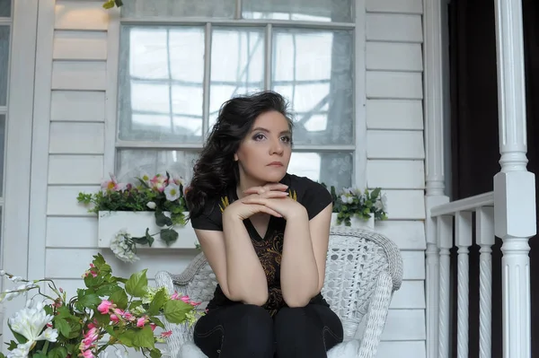 Sad  brunette sitting on the veranda — Stock Photo, Image