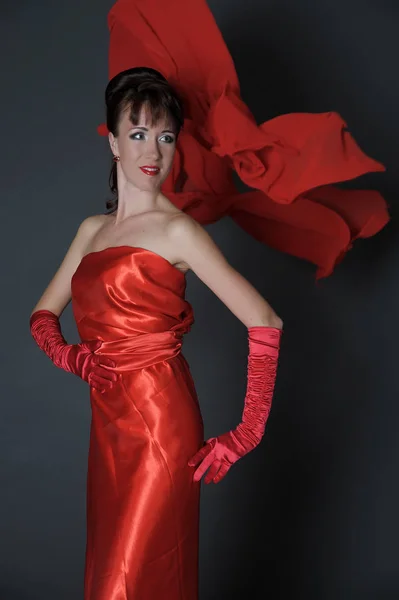 Brunetka w czerwonej sukience na szarym tle w studio i f — Zdjęcie stockowe