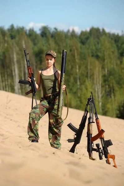 Girl in the summer on a sandy slope with a gun — 스톡 사진