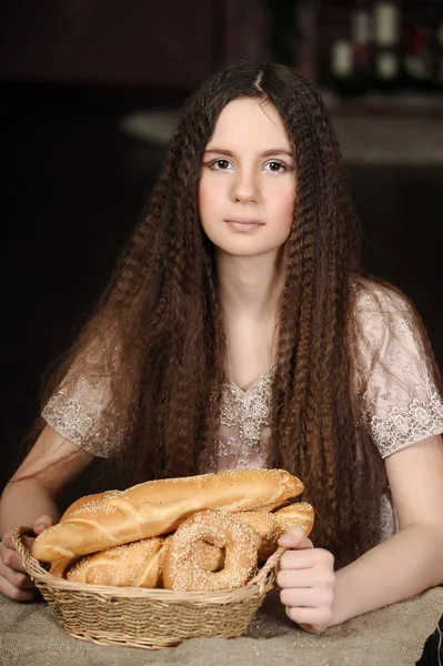 Brunette with a basket with rolls and bagels — Stock Photo, Image