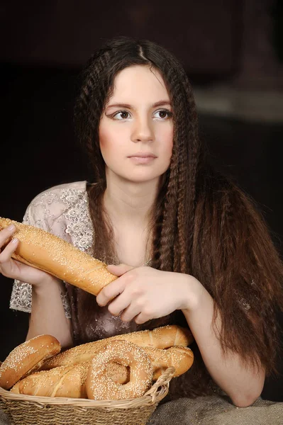 Brunett med en korg med rullar och bagels — Stockfoto