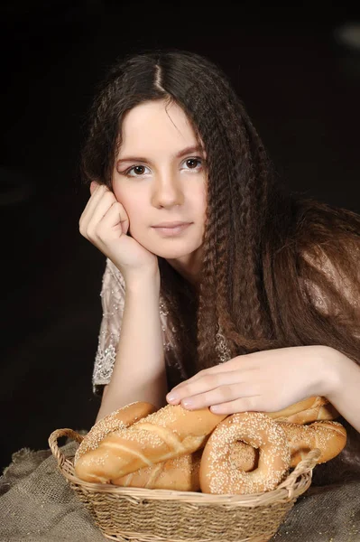 Brunette with a basket with rolls and bagels — Stock Photo, Image
