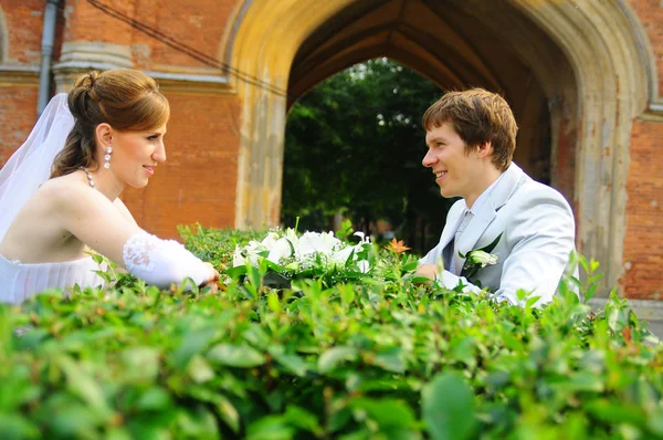 Счастливые молодожены с букетом цветов на свадьбе — стоковое фото