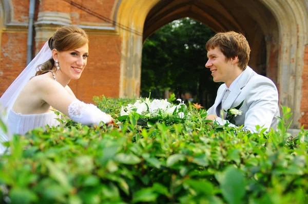 Счастливые молодожены с букетом цветов на свадьбе — стоковое фото