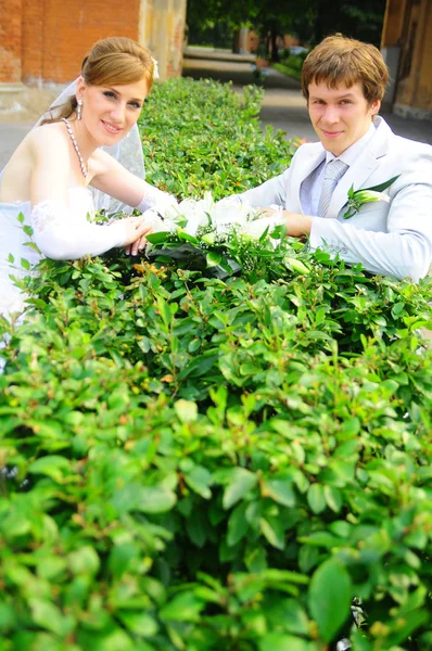 Boldog friss házasok, egy csokor virággal az esküvőjükön — Stock Fotó