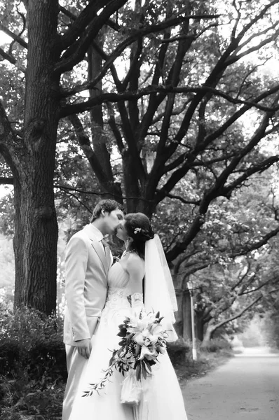 Heureux jeunes mariés avec un bouquet de fleurs ensemble sur leur wedd — Photo