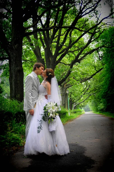 Feliz recém-casados com um buquê de flores juntos em seu casamento — Fotografia de Stock