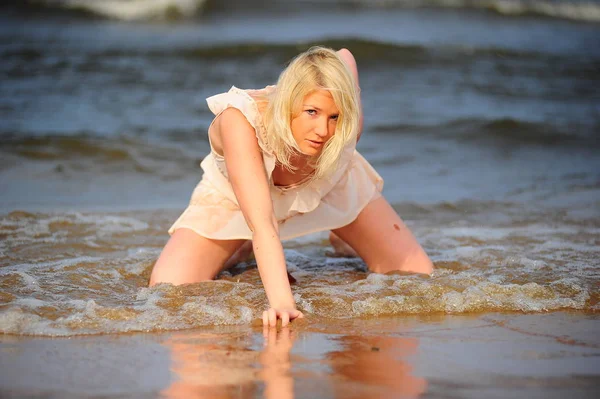 Blonde en robe beige dans le surf — Photo