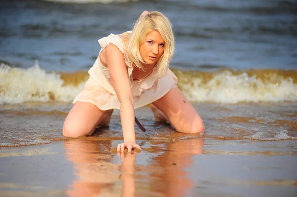 Blonde in a beige dress in the surf — Stock Photo, Image