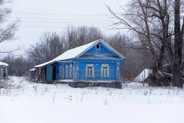 Casa de madera en un pequeño pueblo en invierno — Foto de Stock
