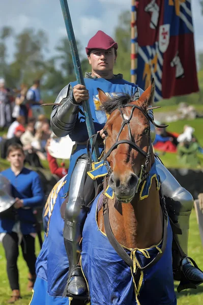 Un caballero con una lanza a caballo en la fortaleza rusa festiva — Foto de Stock