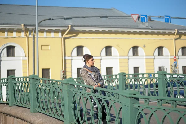Mulher em uma camisola cinza em uma ponte — Fotografia de Stock