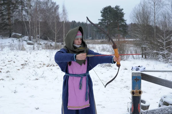Una chica dispara en el invierno de un arco en el festival de mediev —  Fotos de Stock