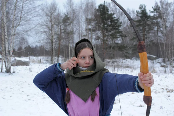 A girl shoots in the winter from a bow at the festival of mediev — Stock Photo, Image